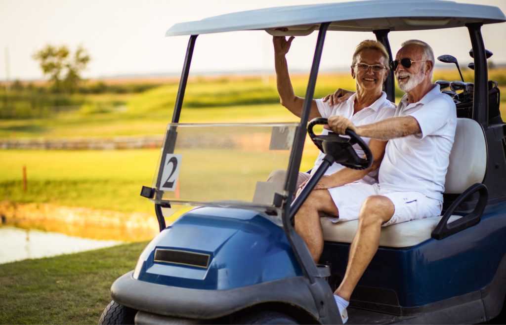 Couple in a golf cart during an active vacation for seniors